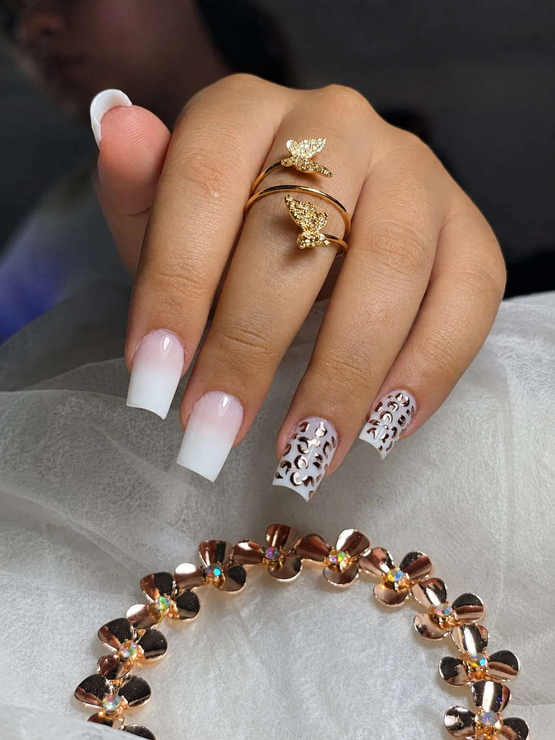Unhas em degradê branco com detalhes metalizados rosé